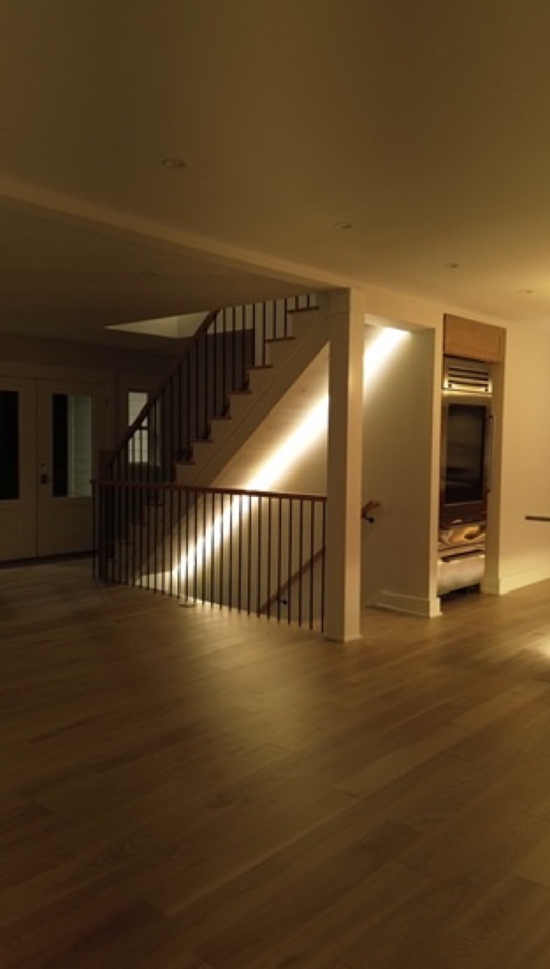 Backlit mirror with LED border and black sconce in Casa DOS bathroom