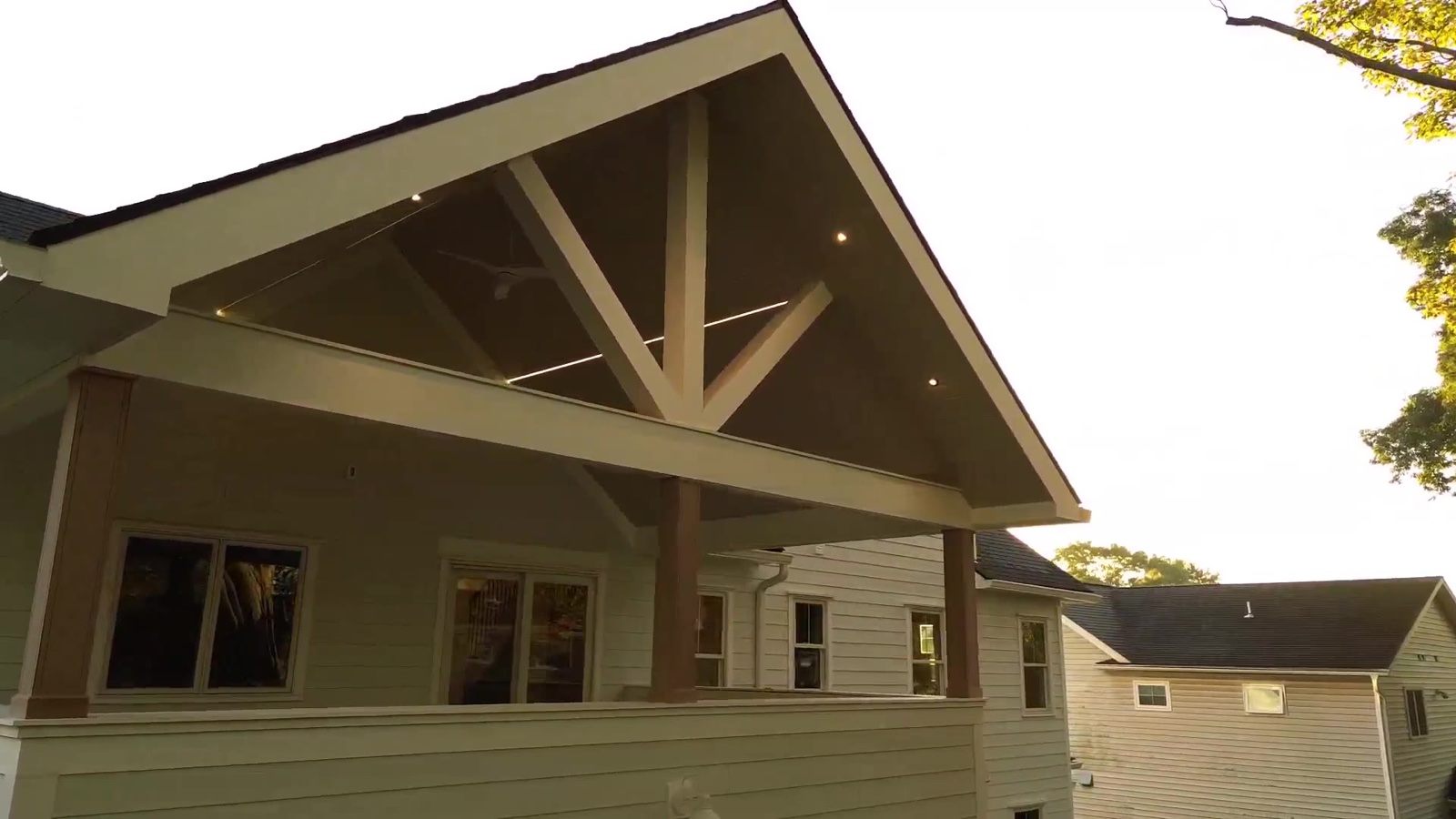 Casa DOS covered porch under timber gable in warm daylight