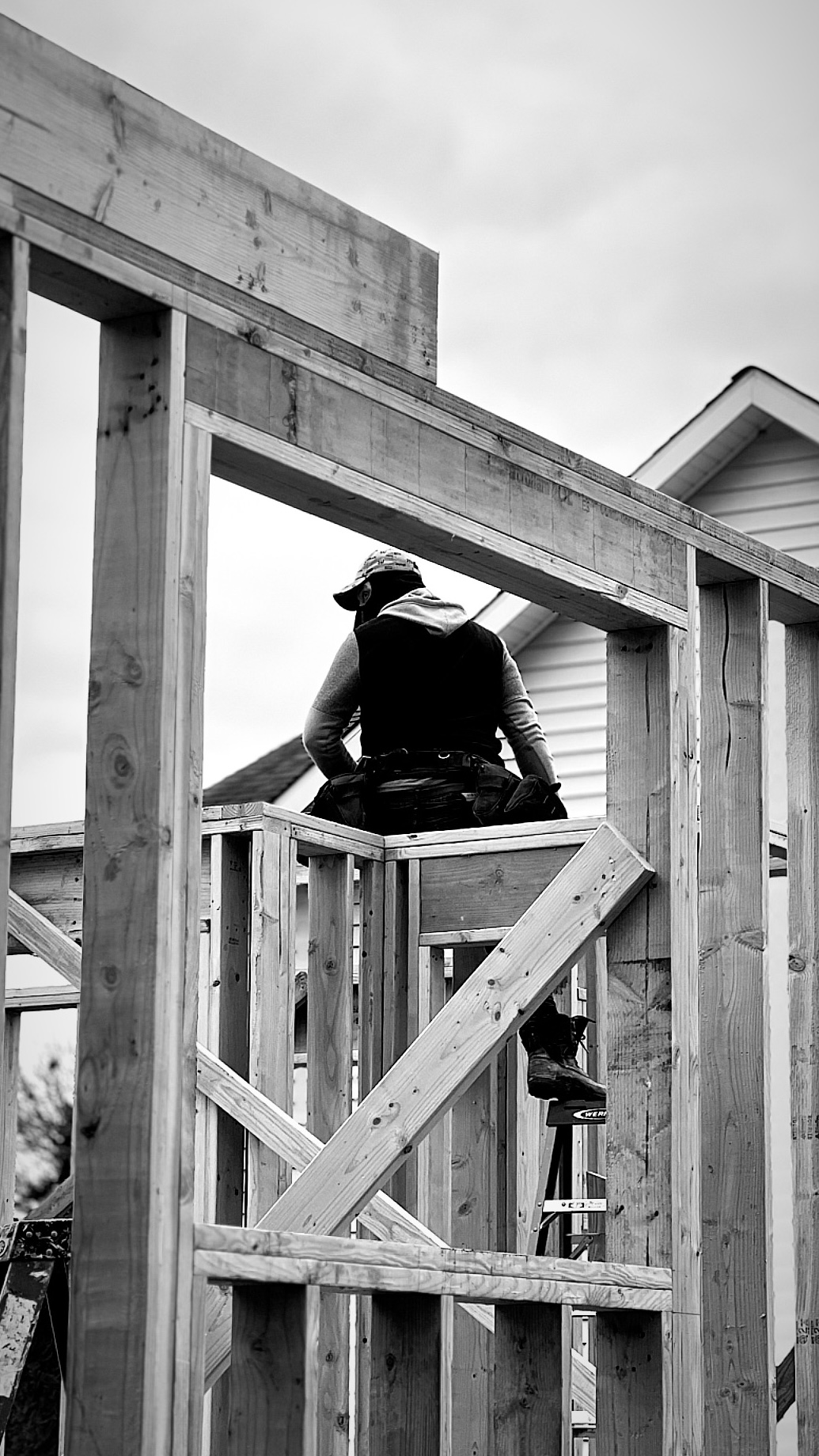 A Cortes crew member on a scaffold against the open sky — the hands behind every Casa