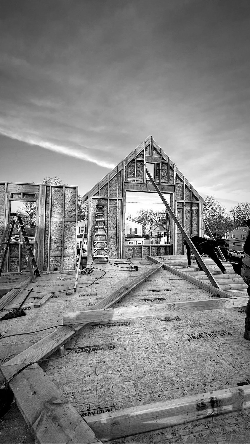 A builder at work on a More Life home, black and white.