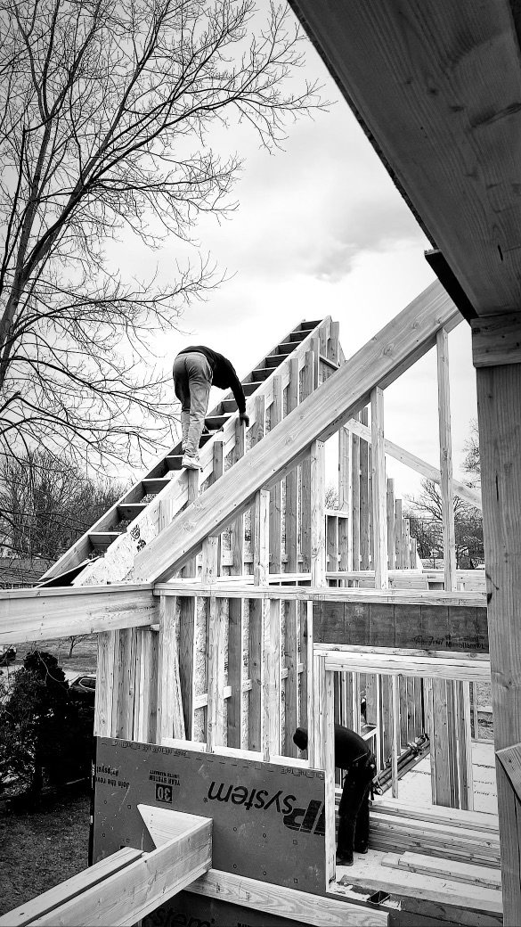 A builder at work on a More Life home, black and white.