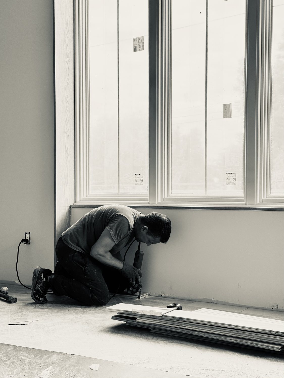 A builder at work on a More Life home, black and white.